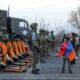 Young boy with Armenian flag standing in front of the Russian army