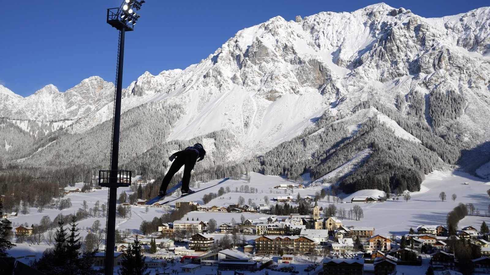 Male Nordic Combined athlete mid-jump