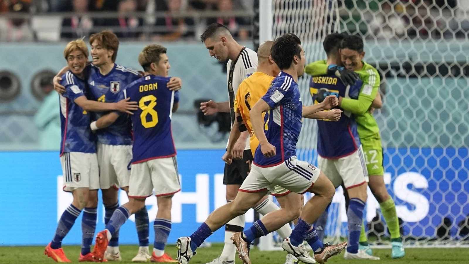 Japanese soccer players celebrating a goal