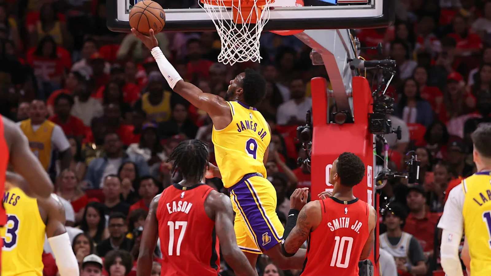 Bronny James in a Lakers jersey performs a layup against Houston Rockets defenders