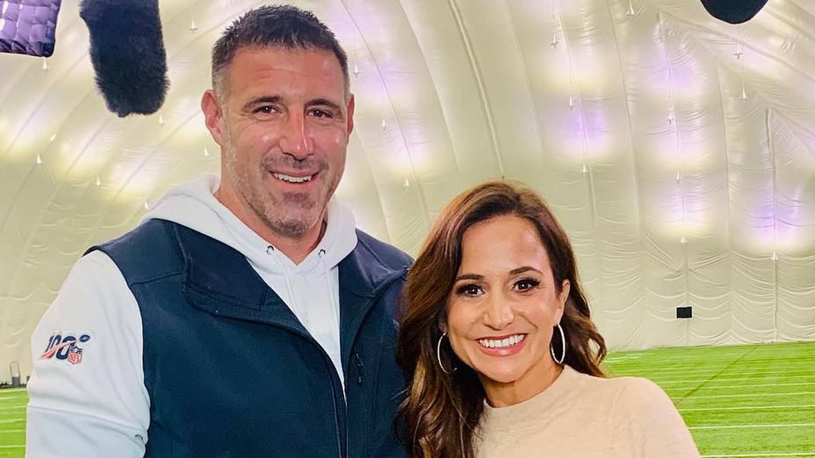 Dianna Russini and Mike Vrabel smiling together during an interview on a field