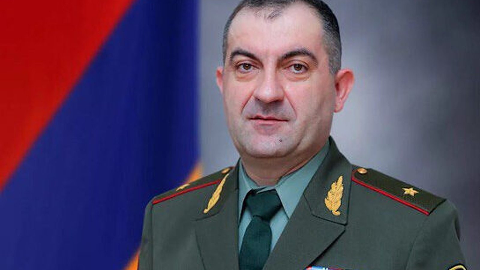 Lieutenant General Edward Asryan in military uniform against an Armenian flag background