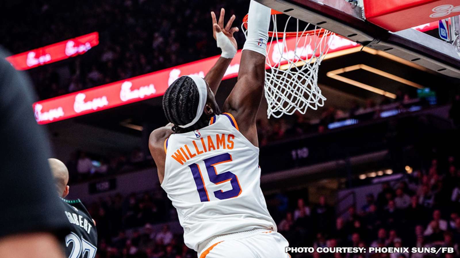 Mark Williams wearing a white Phoenix Suns jersey dunks a basketball into the hoop