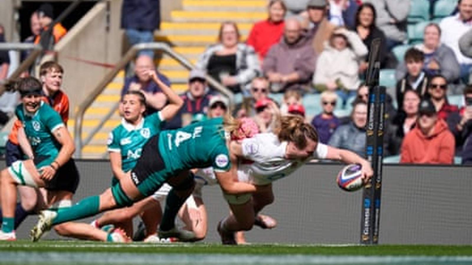 Morwenna Talling in a green jersey making a tackle during a rugby match