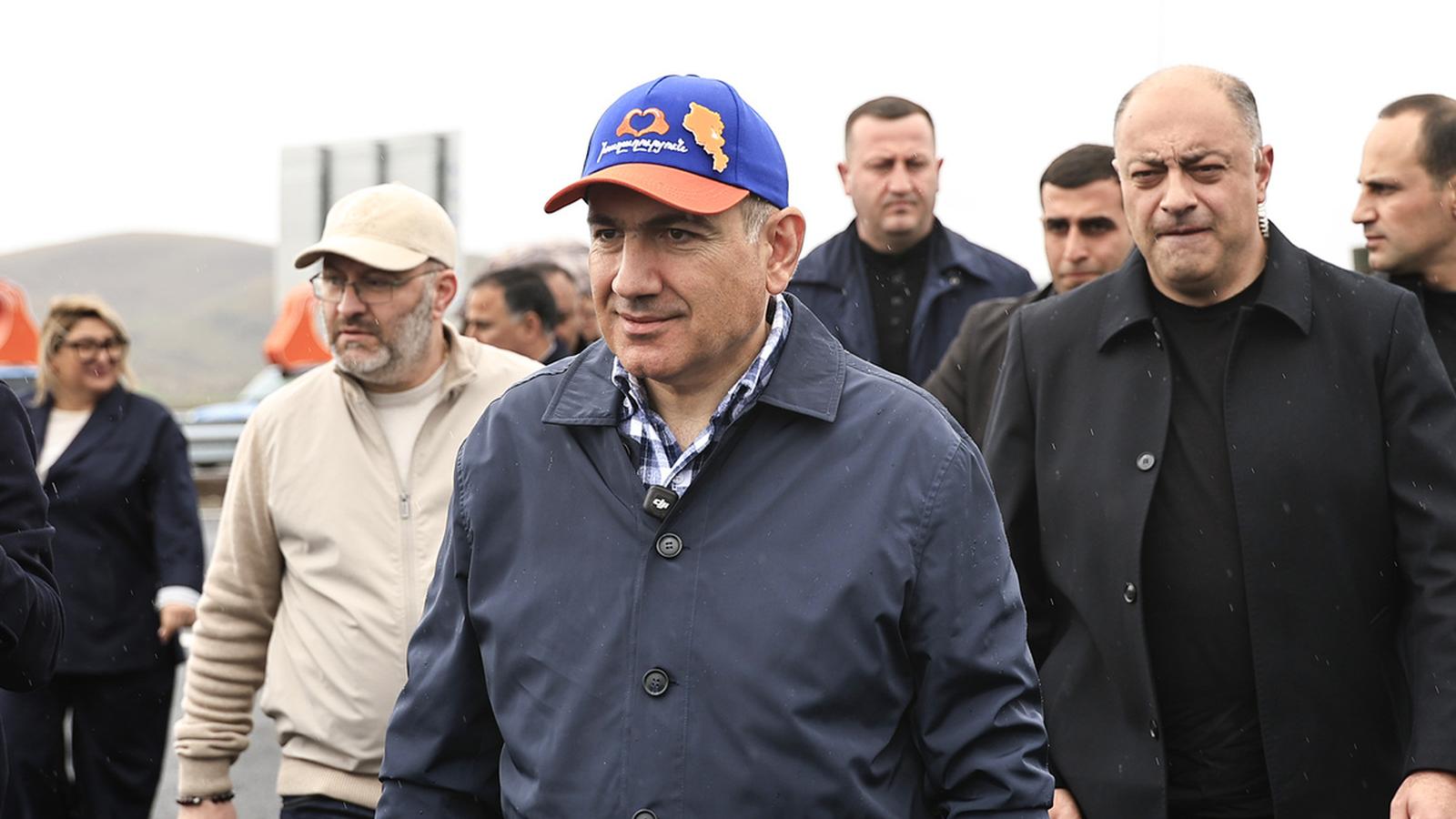 Prime Minister Nikol Pashinyan walking with officials during the North-South road inauguration