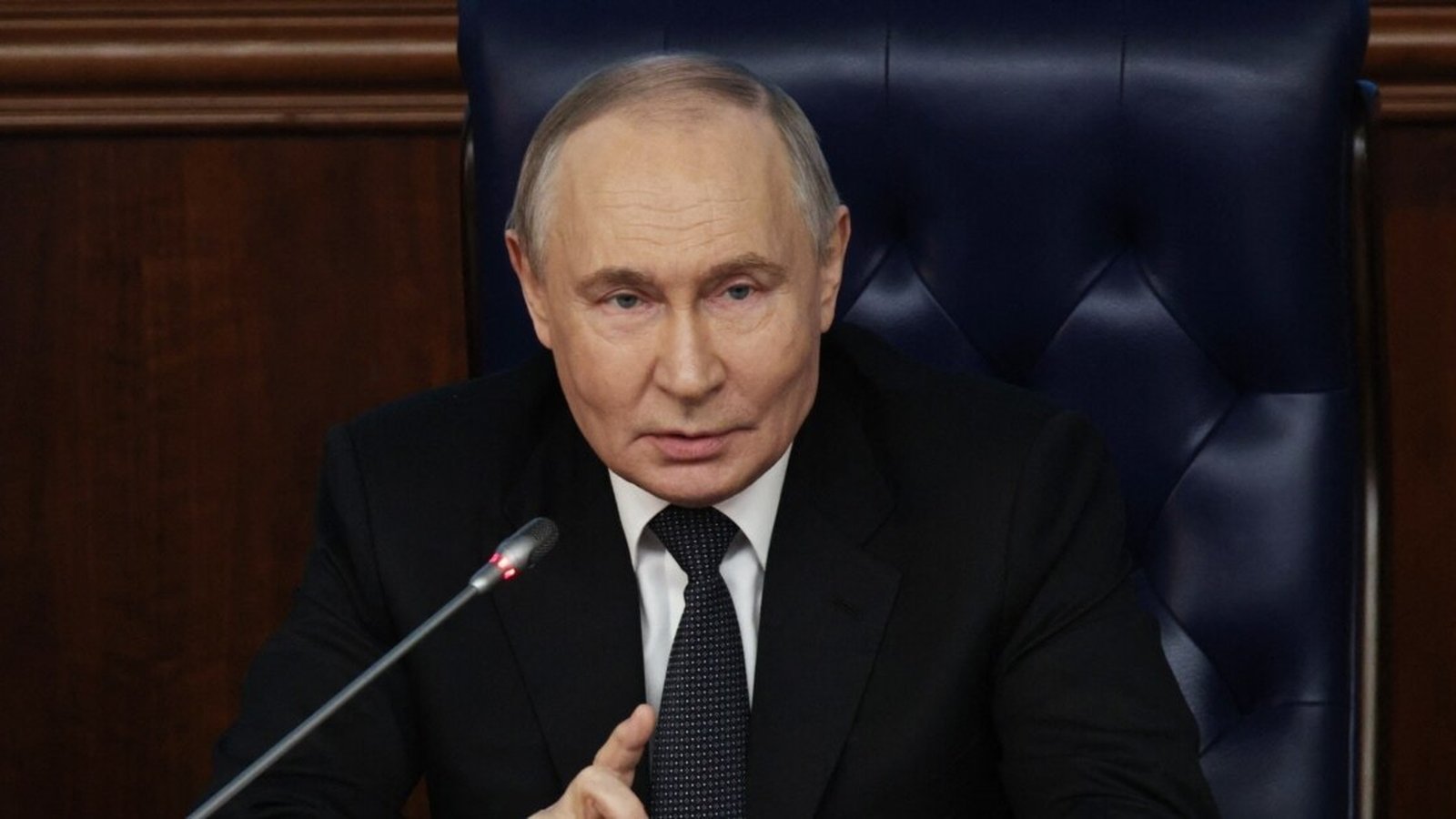 Russian President Vladimir Putin speaking at a formal meeting with a microphone in front