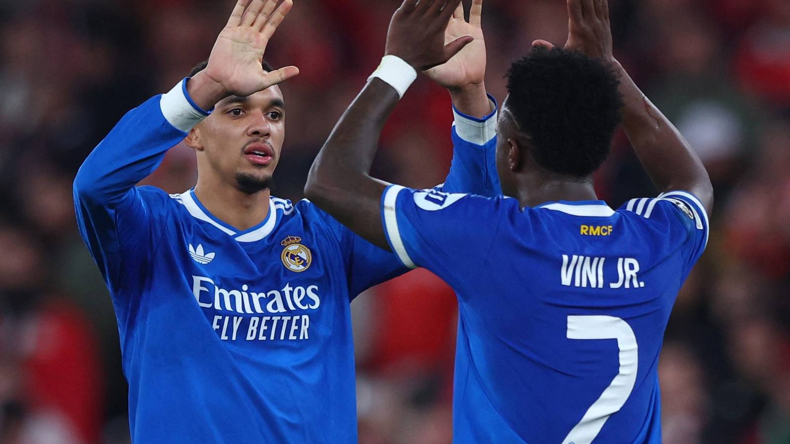 Real Madrid players Vinicius Junior and teammate celebrating a goal in blue jerseys