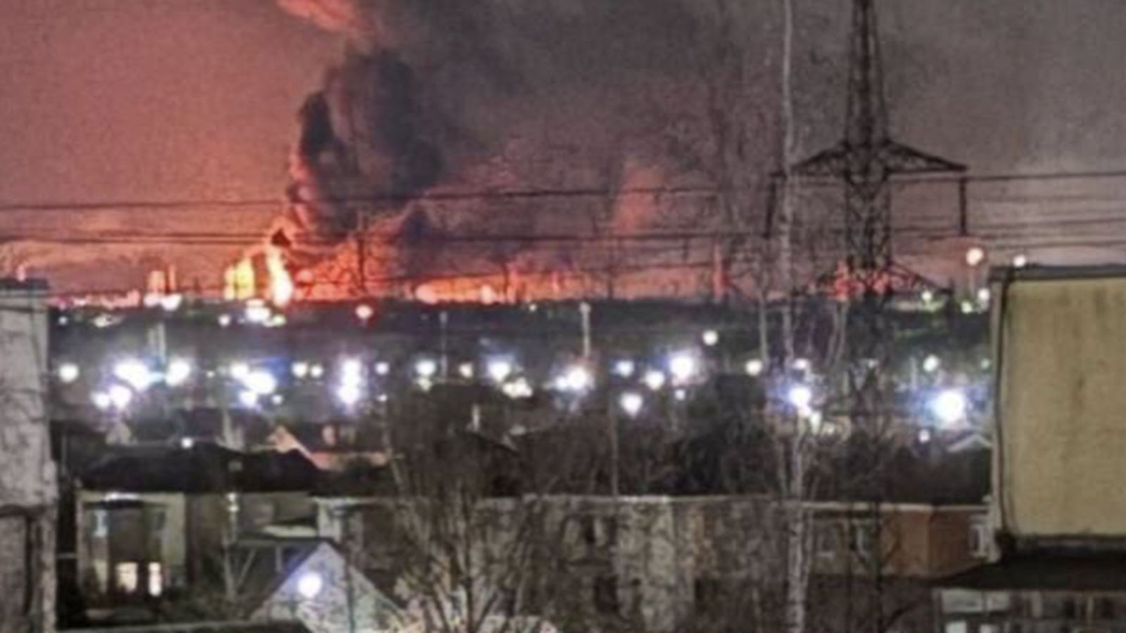 A large fire and thick smoke rising from an industrial facility at night