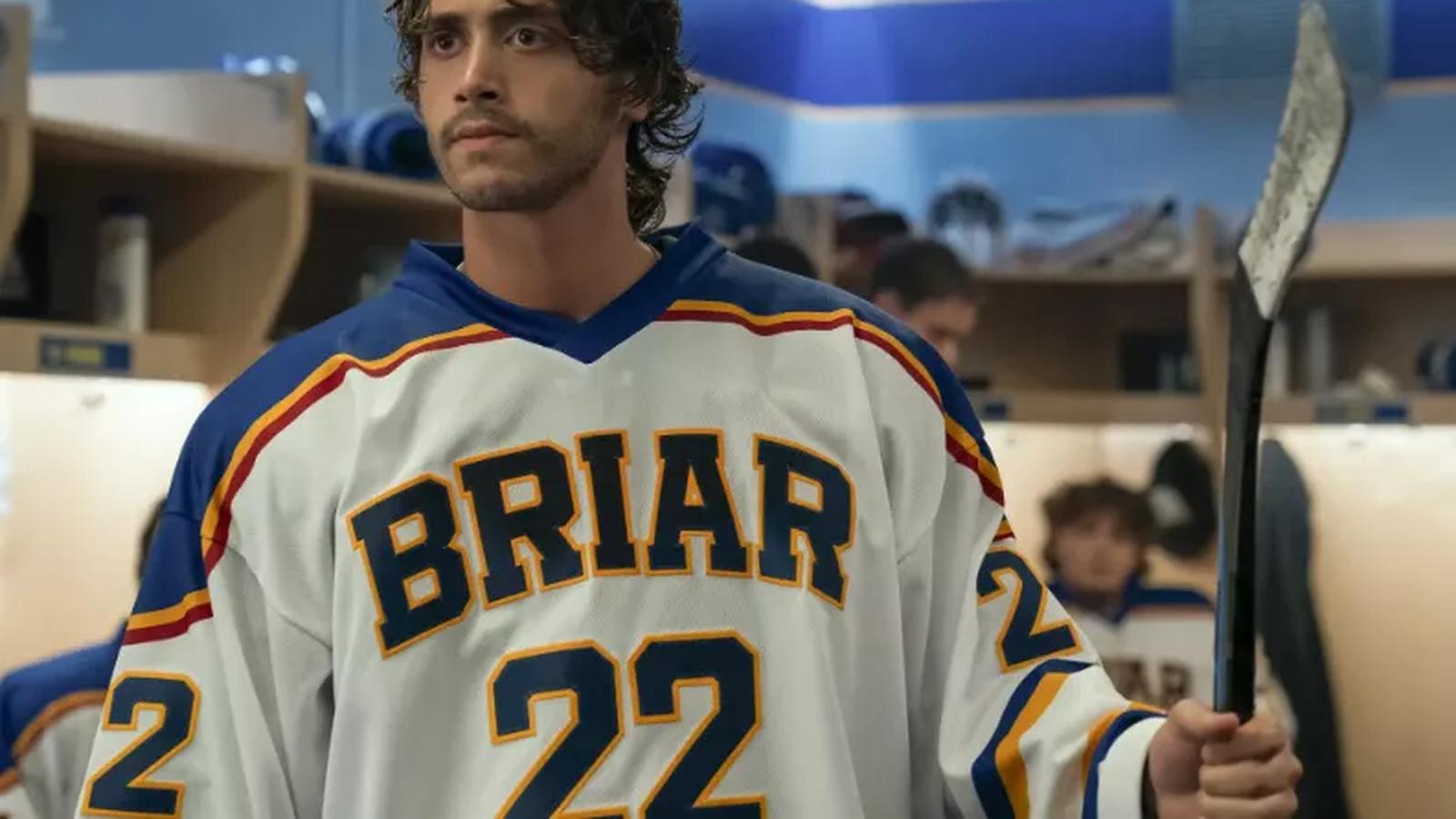 Antonio Cipriano wearing a Briar hockey jersey holding a stick in a locker room