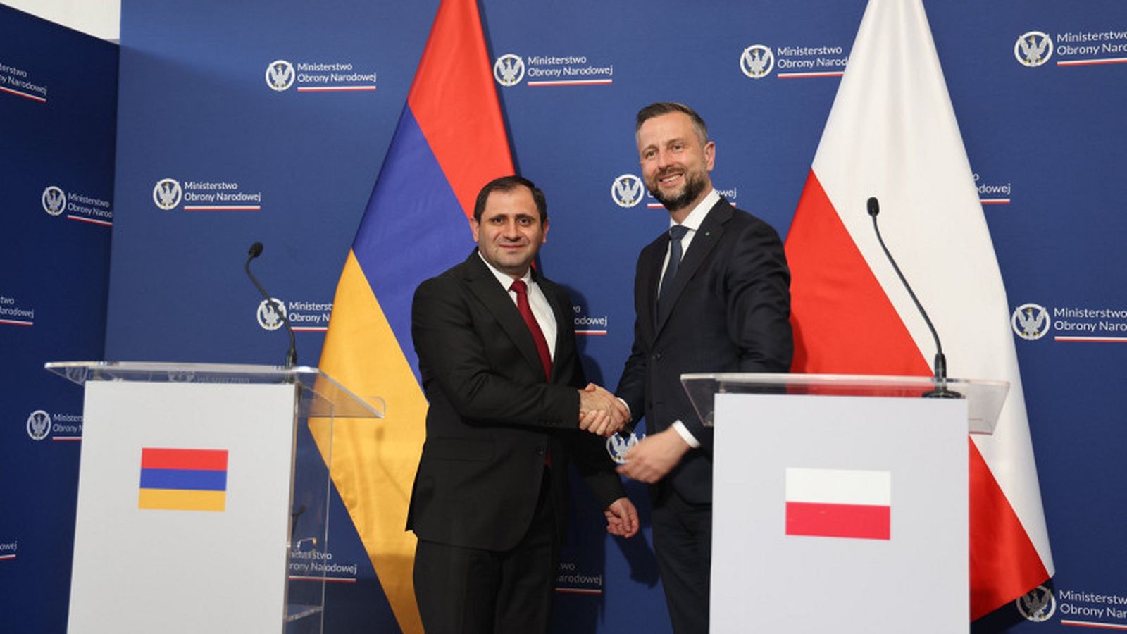 Armenian and Polish defense ministers shake hands during a formal meeting in Warsaw