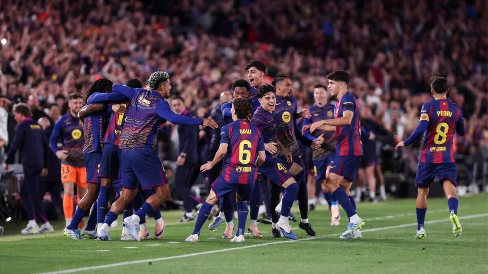 FC Barcelona football players in blue and red kits celebrating a goal together