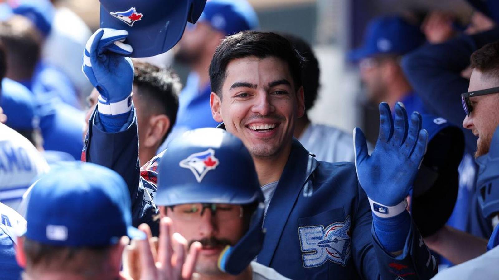 Brandon Valenzuela smiling while celebrating with teammates in the Blue Jays dugout