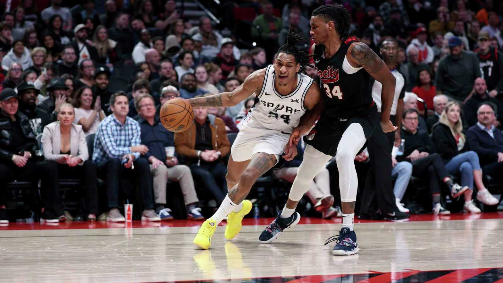 San Antonio Spurs guard Devin Vassell dribbling the basketball against a defender on court