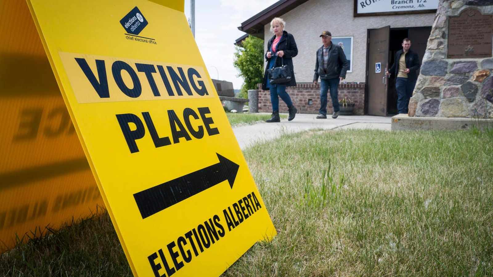 A yellow Elections Alberta voting place sign outside a Royal Canadian Legion building