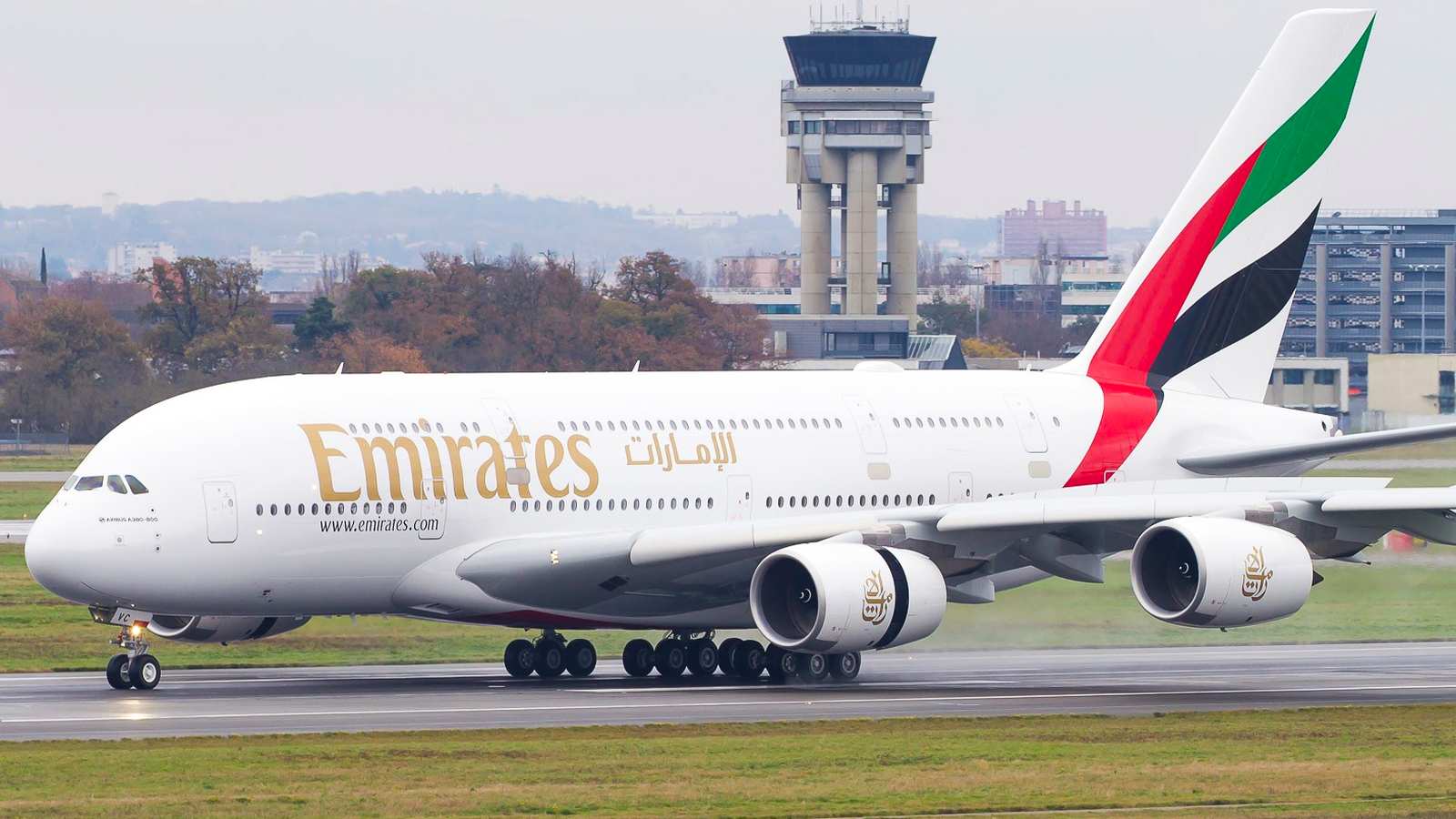 Large white Emirates Airbus A380 superjumbo aircraft with four engines on a runway