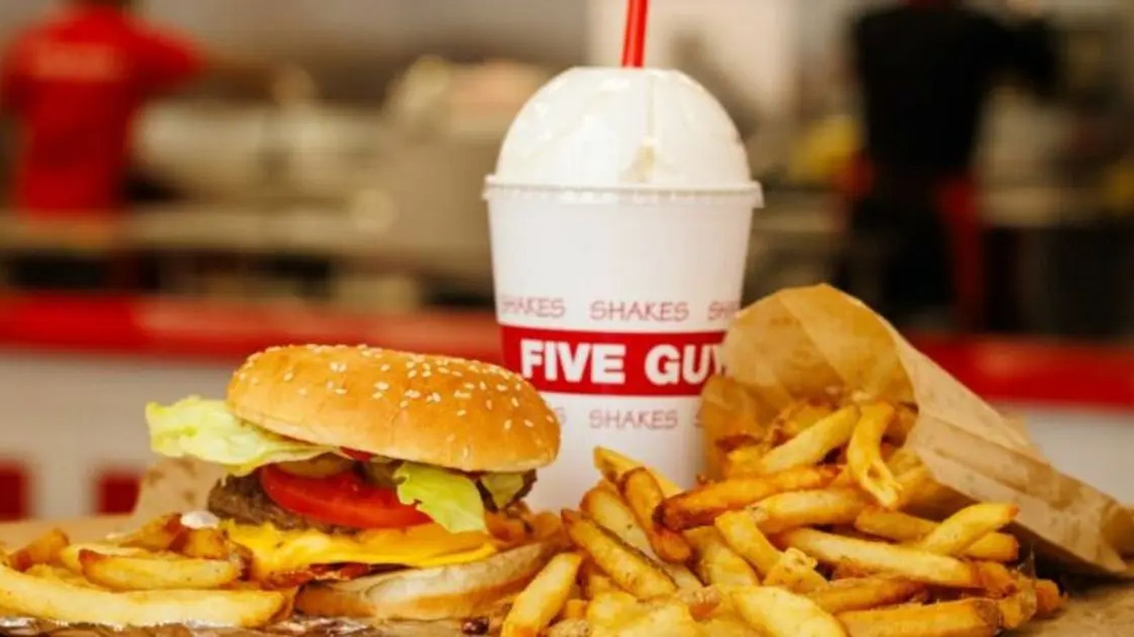A classic Five Guys cheeseburger, a paper bag of fries, and a milkshake