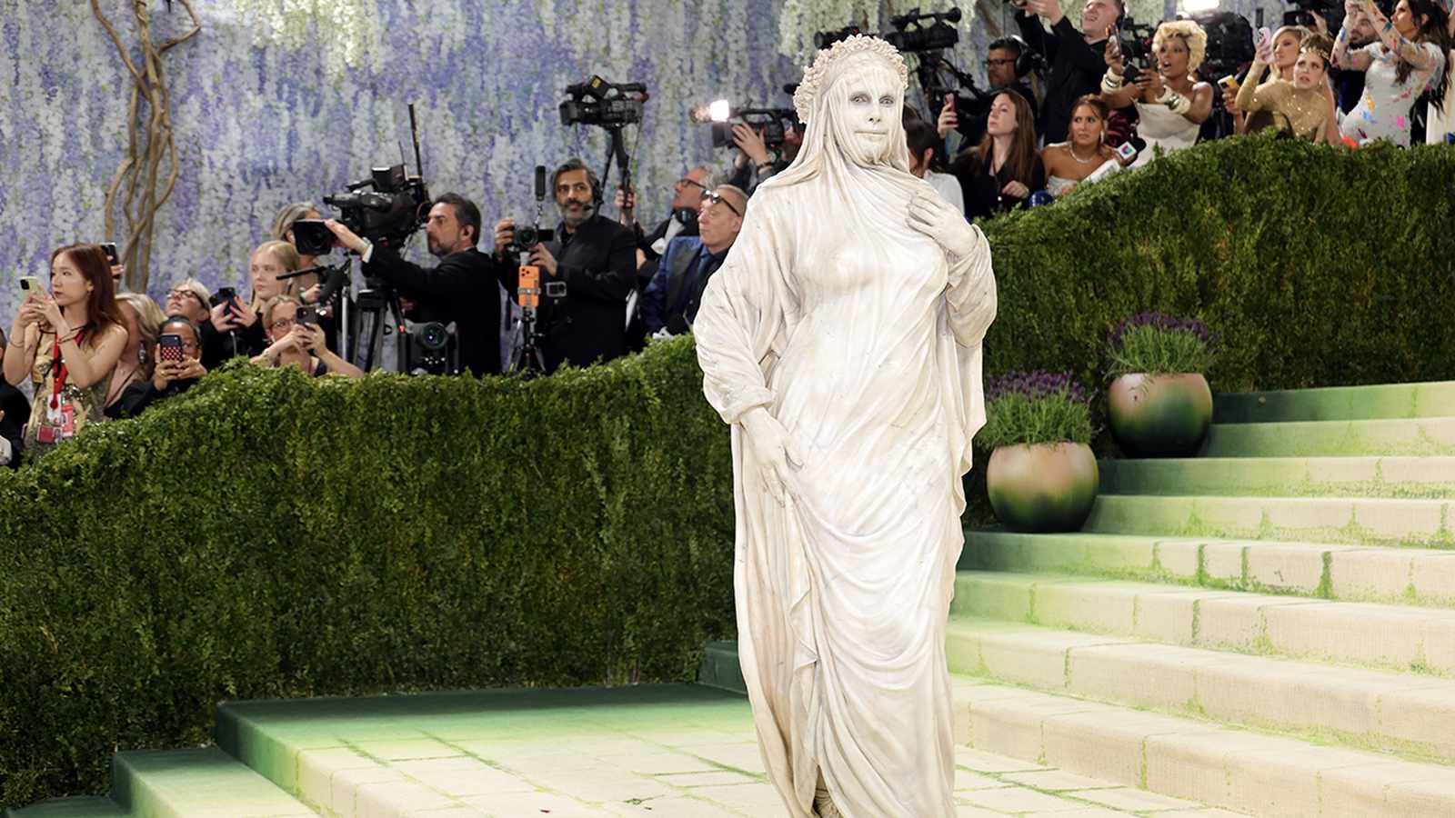 Heidi Klum wearing a hyper-realistic stone statue costume at the Met Gala