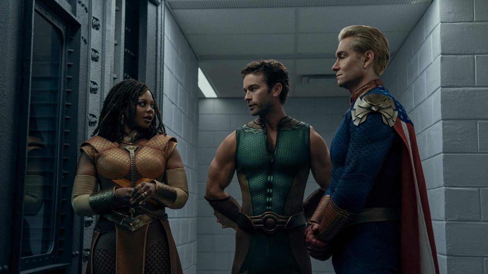 Homelander, The Deep, and Queen Maeve stand in a sterile hallway, looking serious