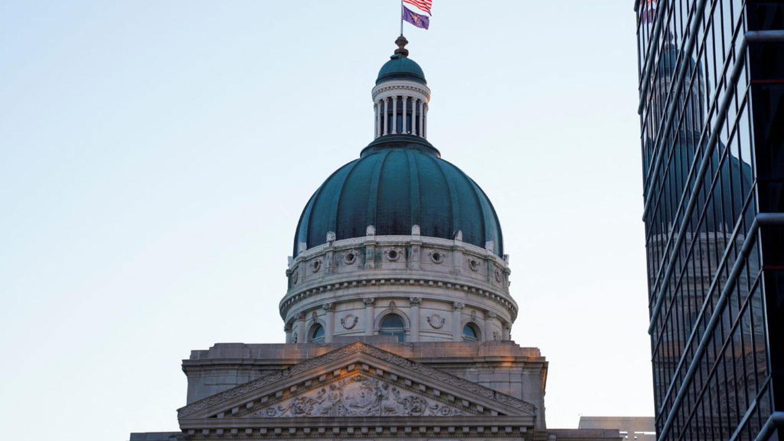 The copper dome of the Indiana Statehouse building against a clear sky