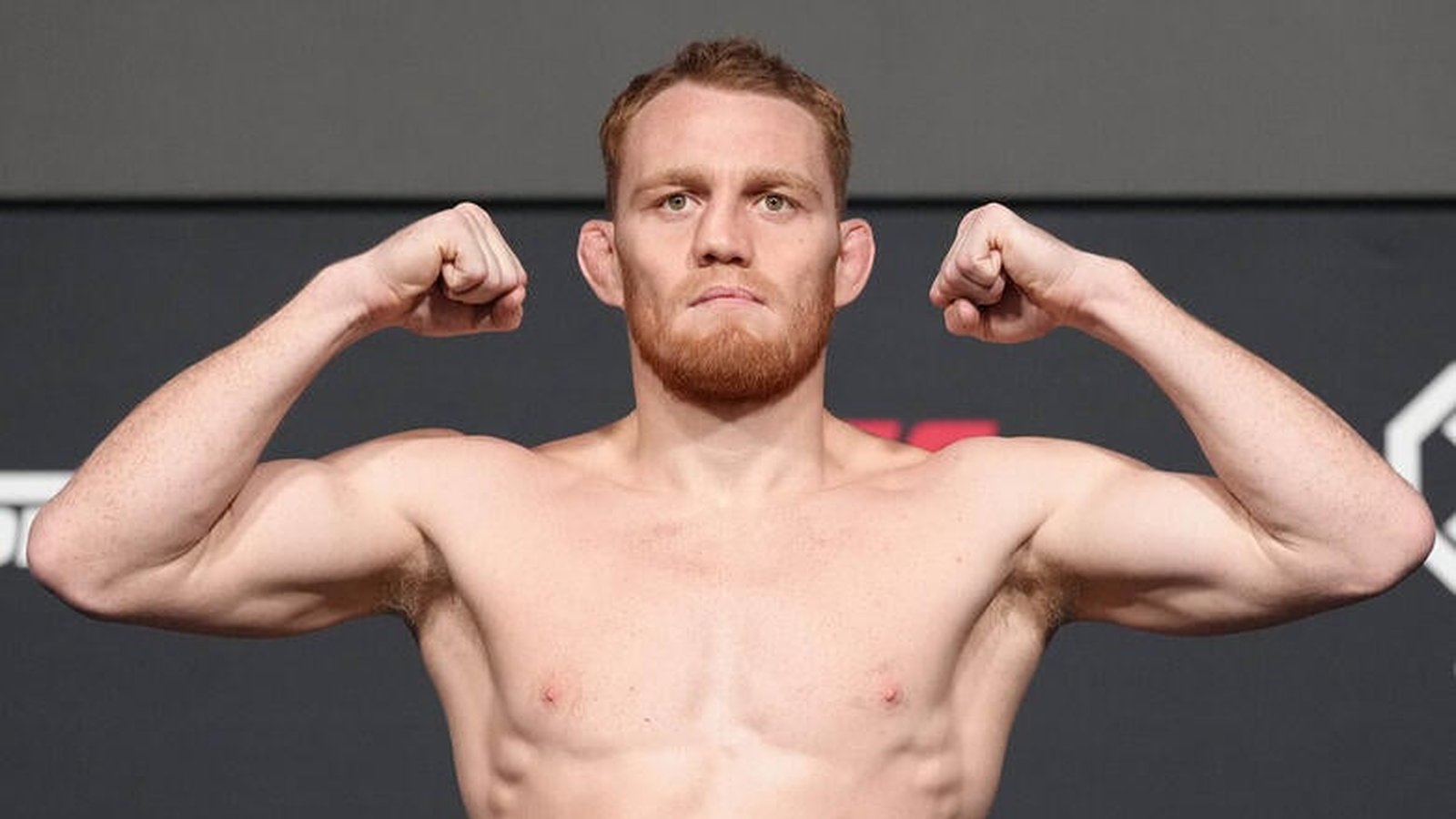 UFC fighter Jack Della Maddalena flexing his muscles during a weigh in session