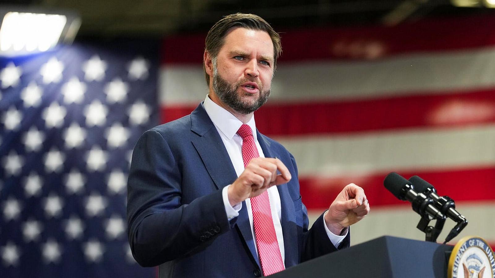 Vice President JD Vance speaking at a podium with an American flag background