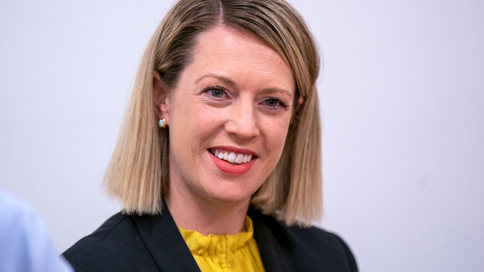 Jenny Gilruth smiling during a professional appearance in a yellow blouse and blazer