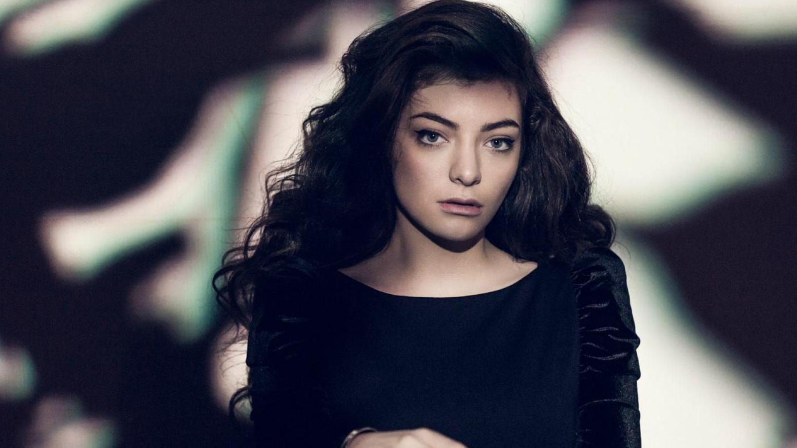 Portrait of singer Lorde with long dark hair looking directly at the camera