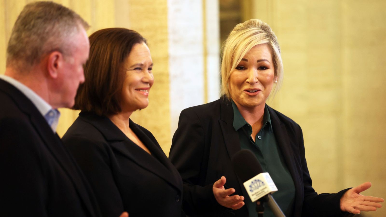 Northern Ireland First Minister Michelle ONeill speaking into a microphone at a press event