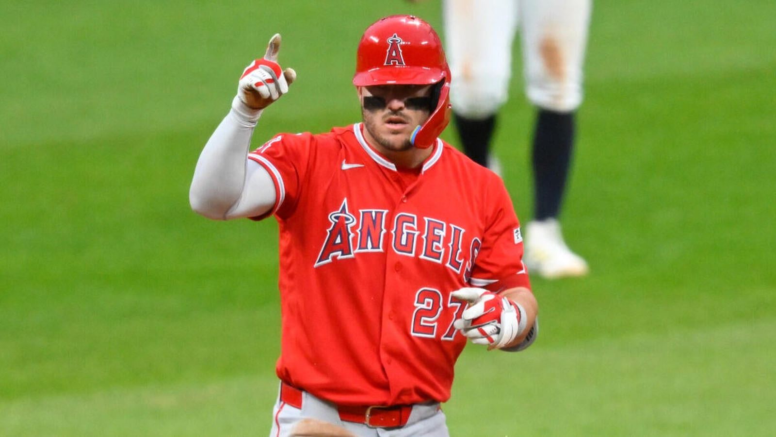 Mike Trout wearing a red Los Angeles Angels jersey pointing toward the sky