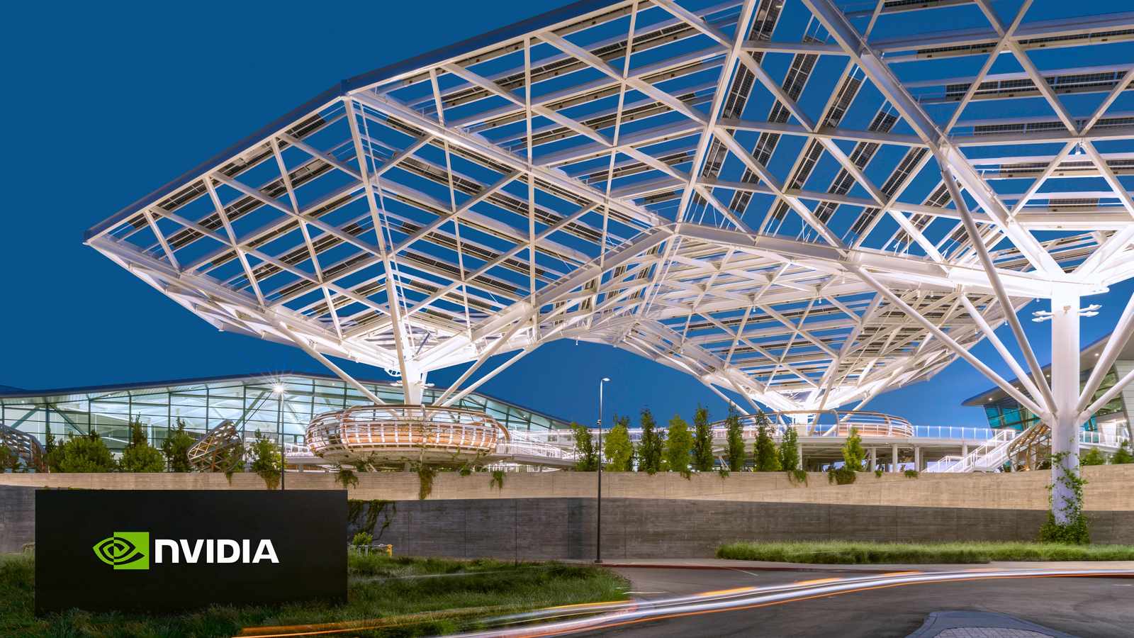 The modern Nvidia corporate headquarters building with a large illuminated logo sign at night