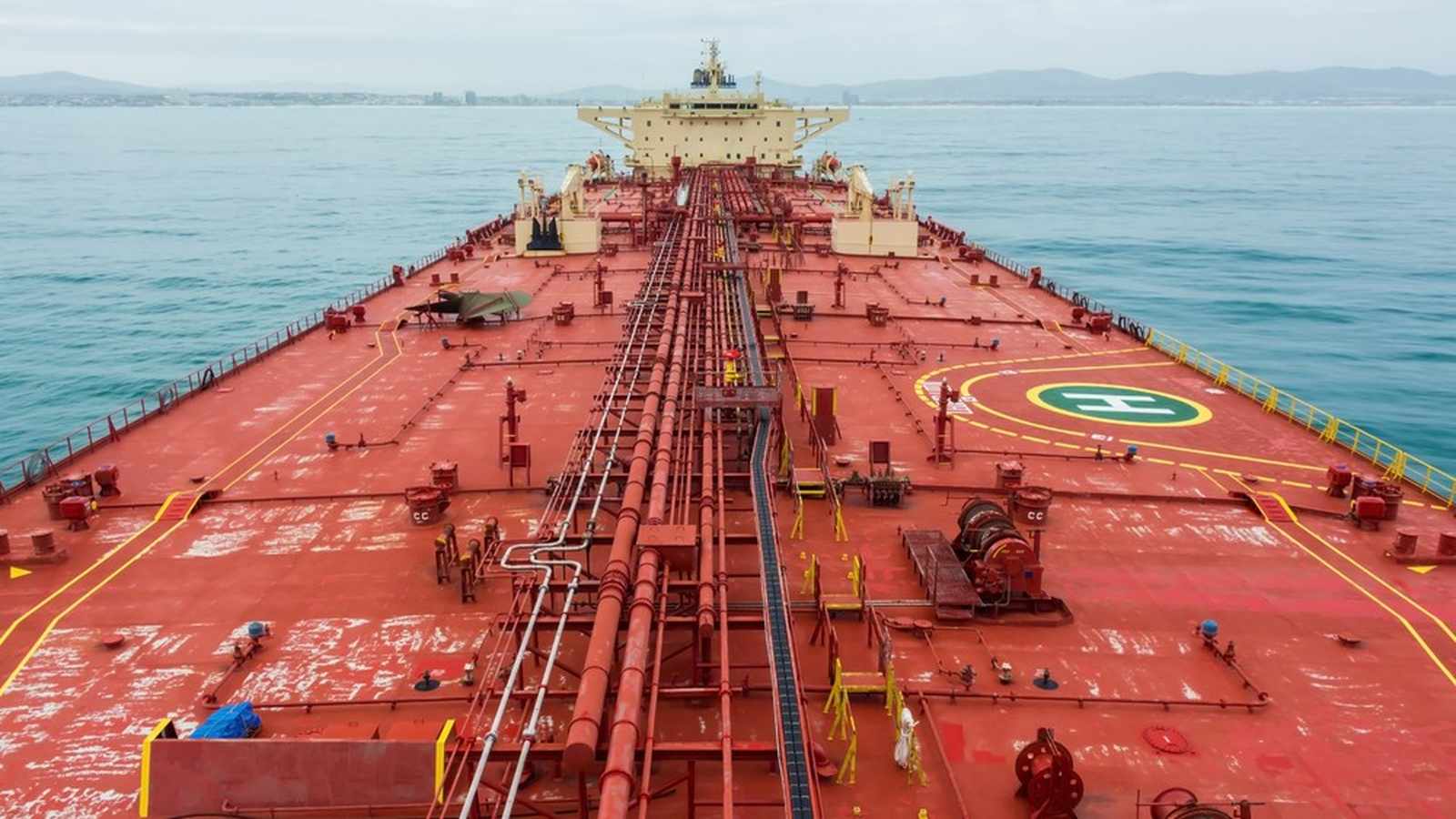 A high angle view looking down the red deck of a large oil tanker ship
