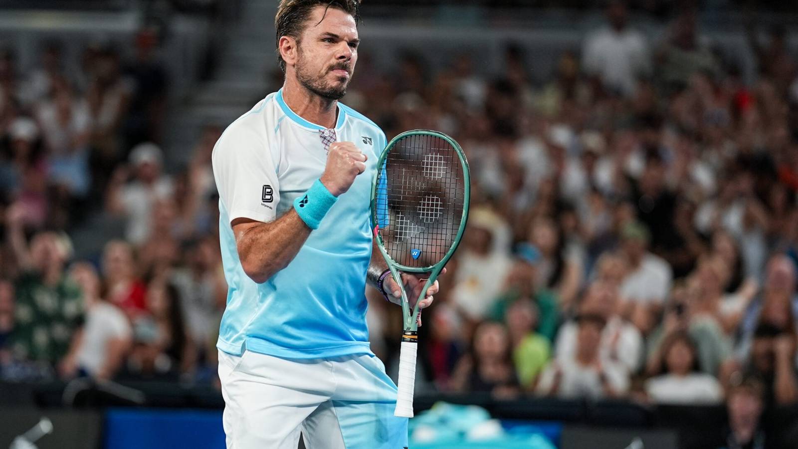 Stan Wawrinka clenching his fist in celebration while holding a tennis racket