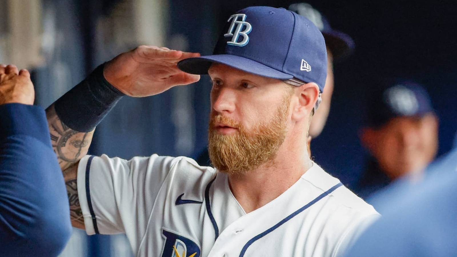 A Tampa Bay Rays baseball player with a red beard saluting in uniform