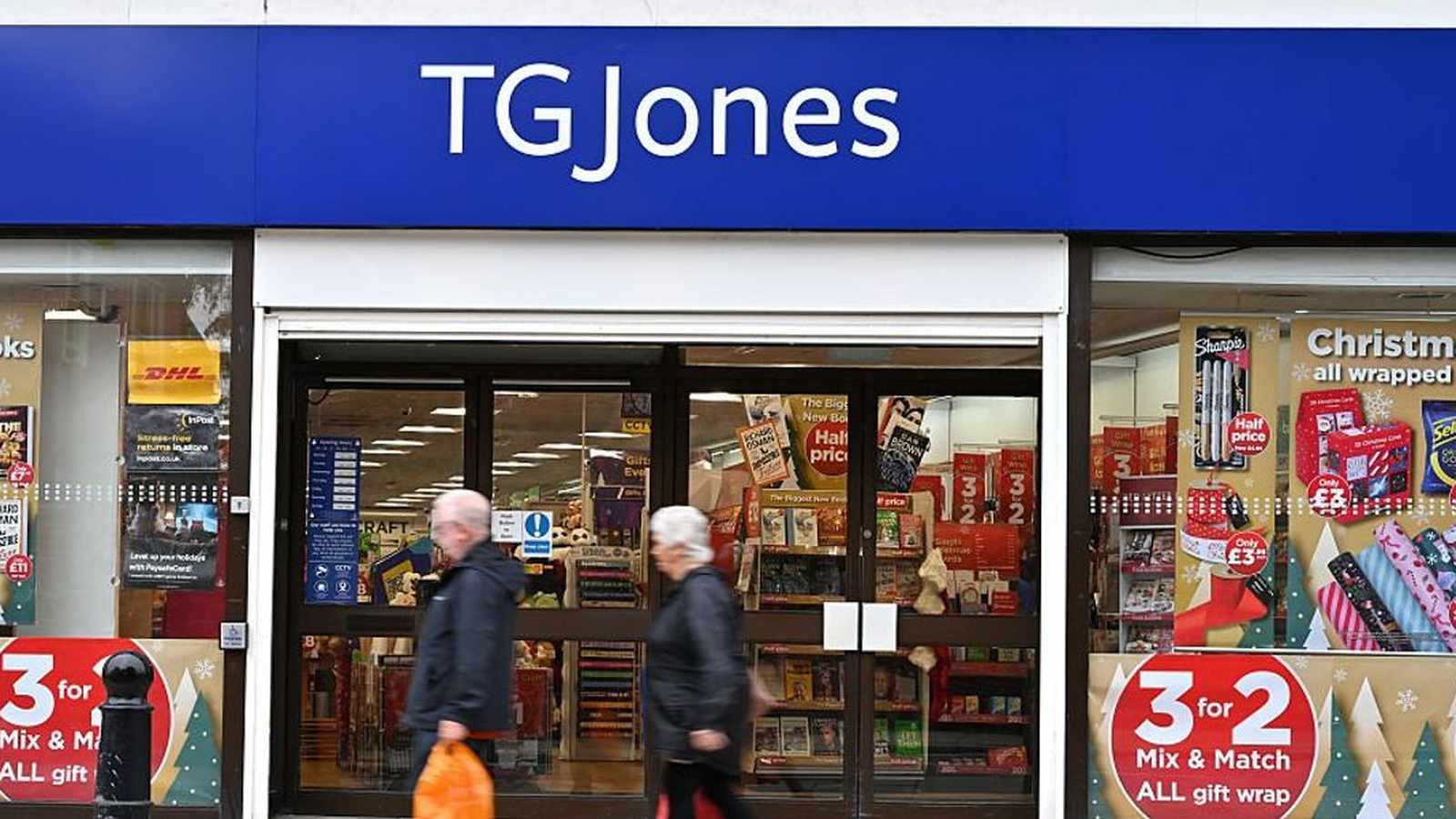 The exterior storefront of a TG Jones retail shop with promotional window signage