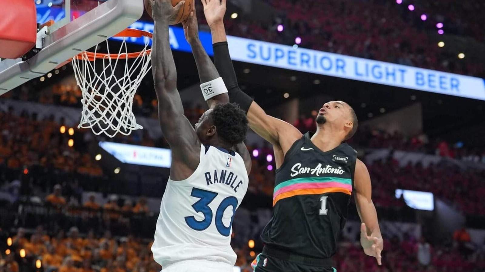 Victor Wembanyama blocks a shot attempt by Julius Randle near the basketball hoop