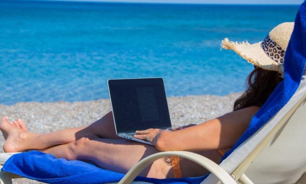 lying on the beach and working