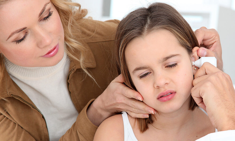 Doctor looking at little girl ear infection