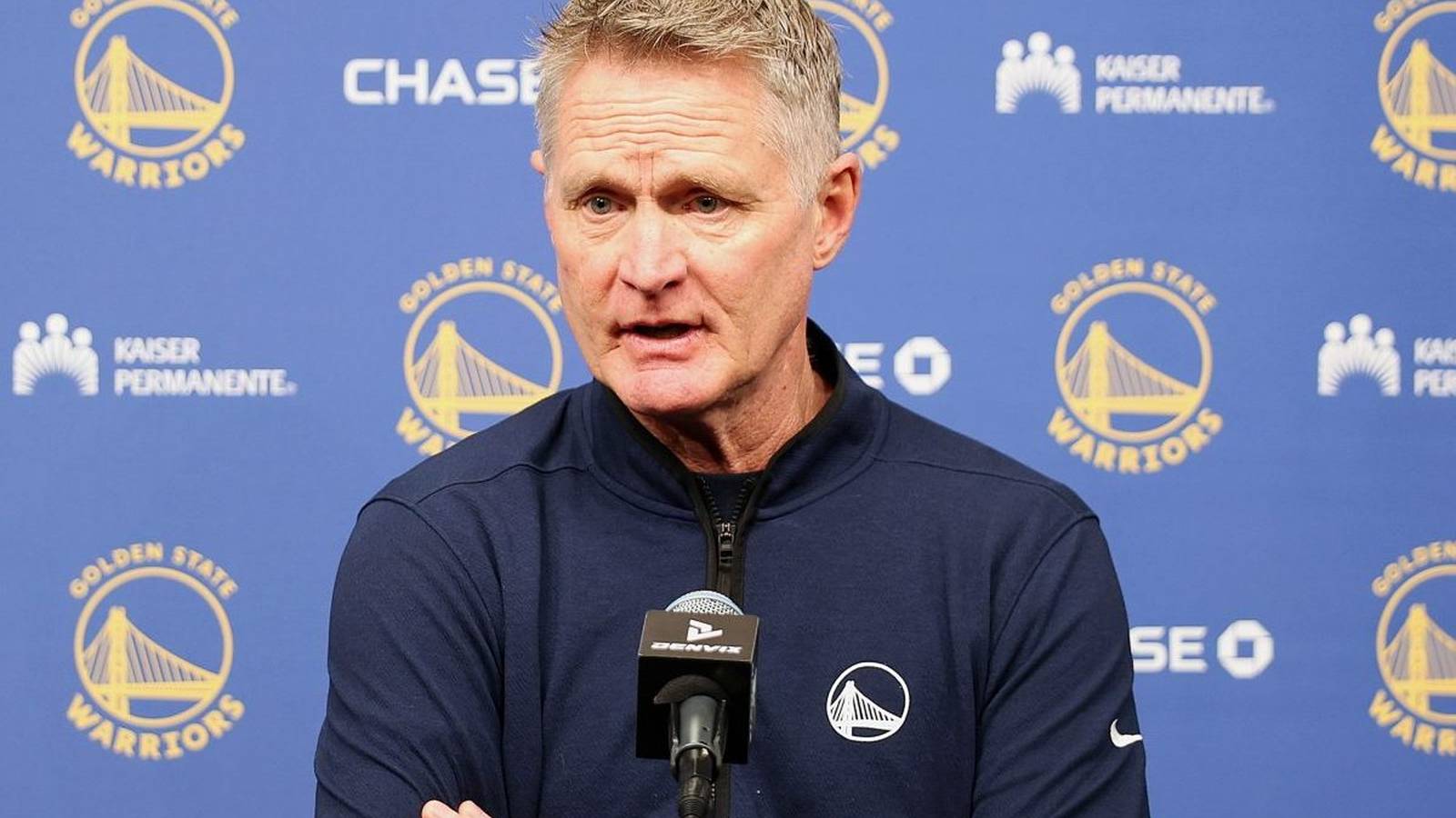 Steve Kerr in a suit on the basketball court