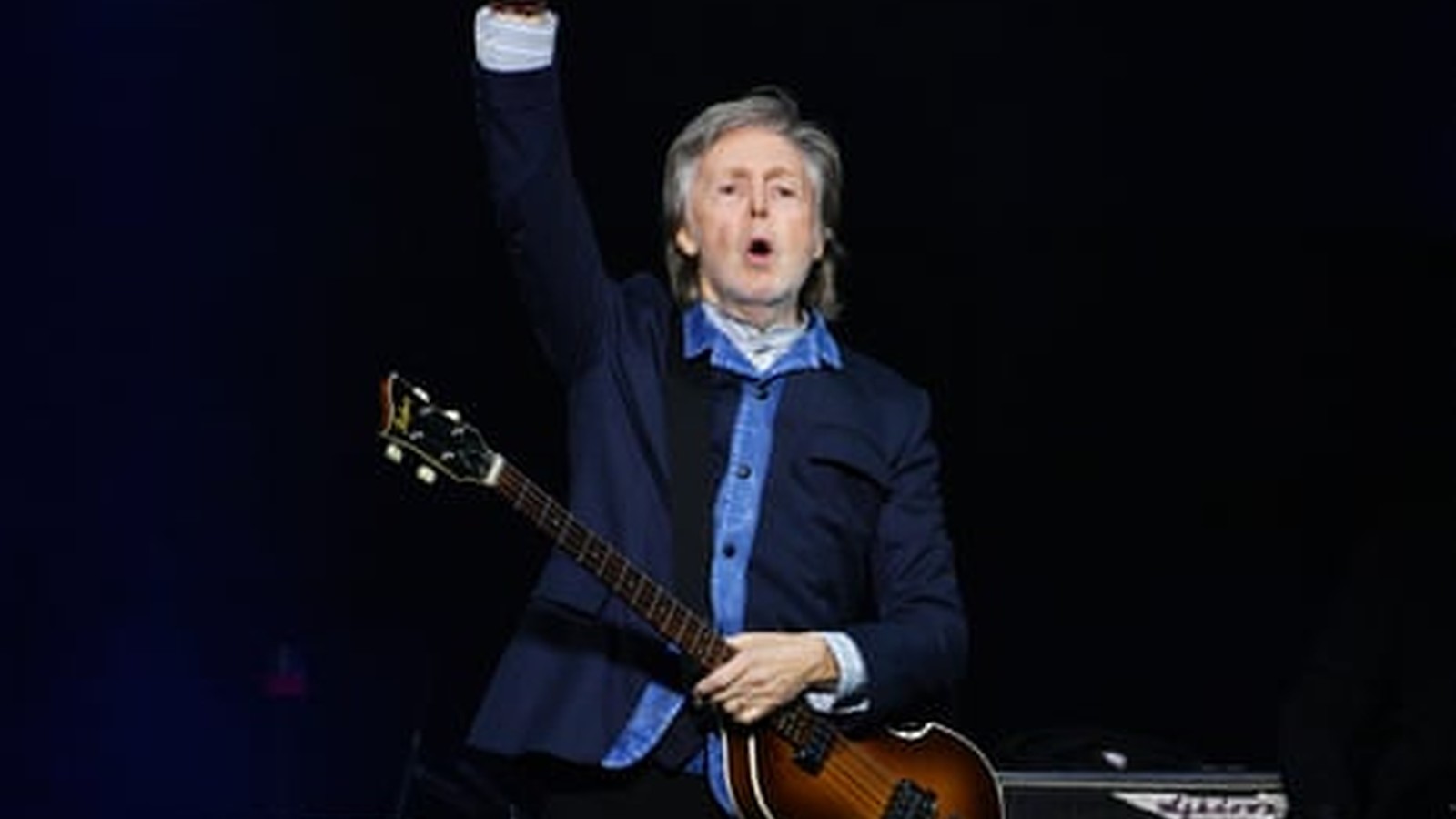 Paul McCartney holding guitar during interview