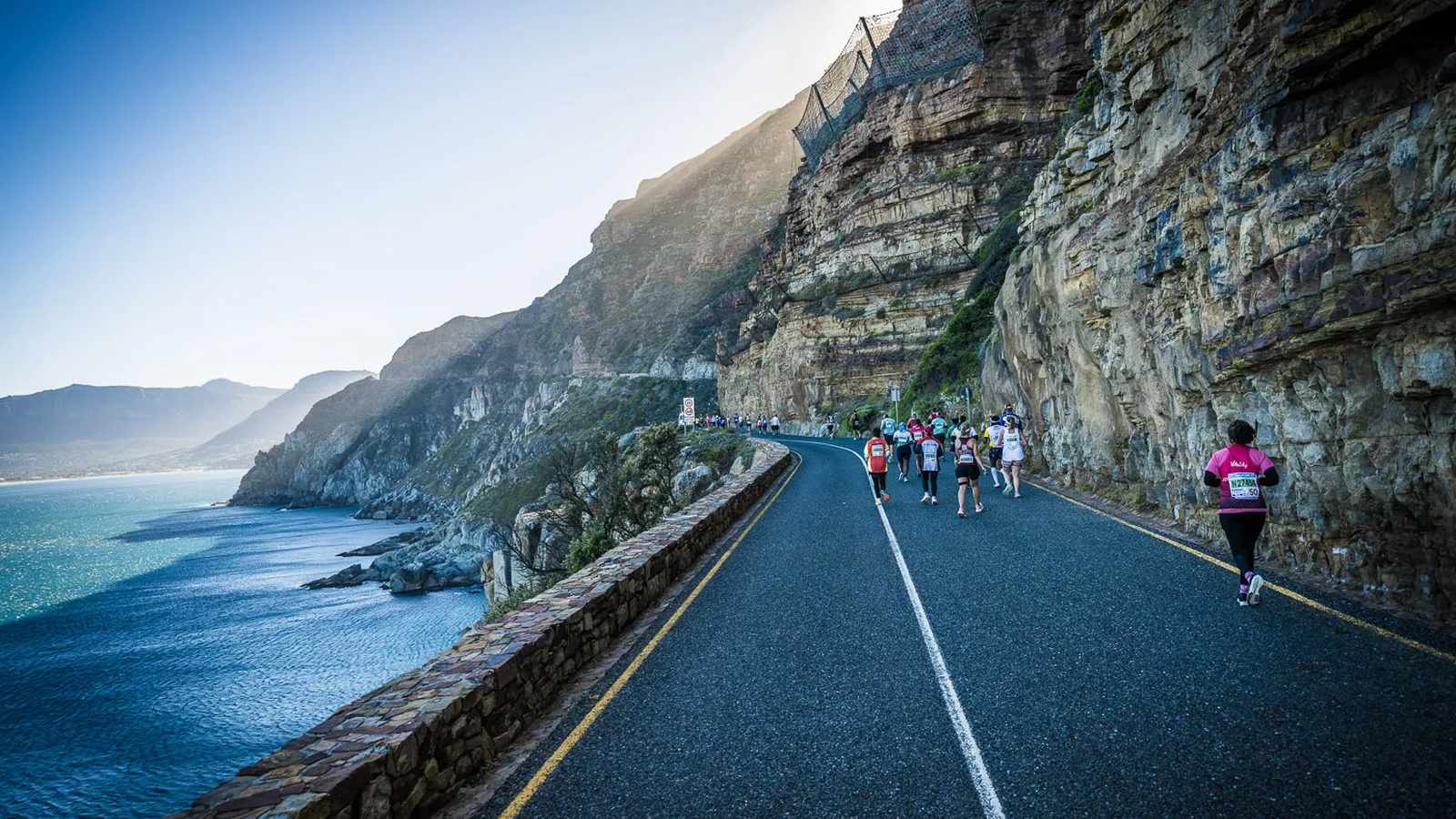 Runners on scenic coastal road
