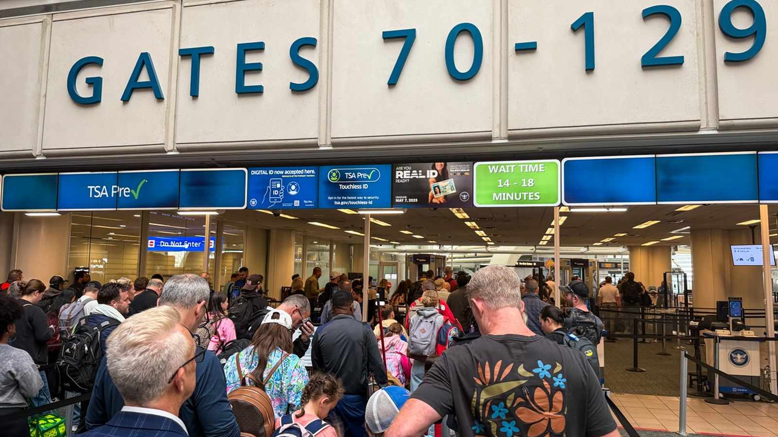 A large crowd of travelers waiting in a security line at Detroit Metropolitan Airport