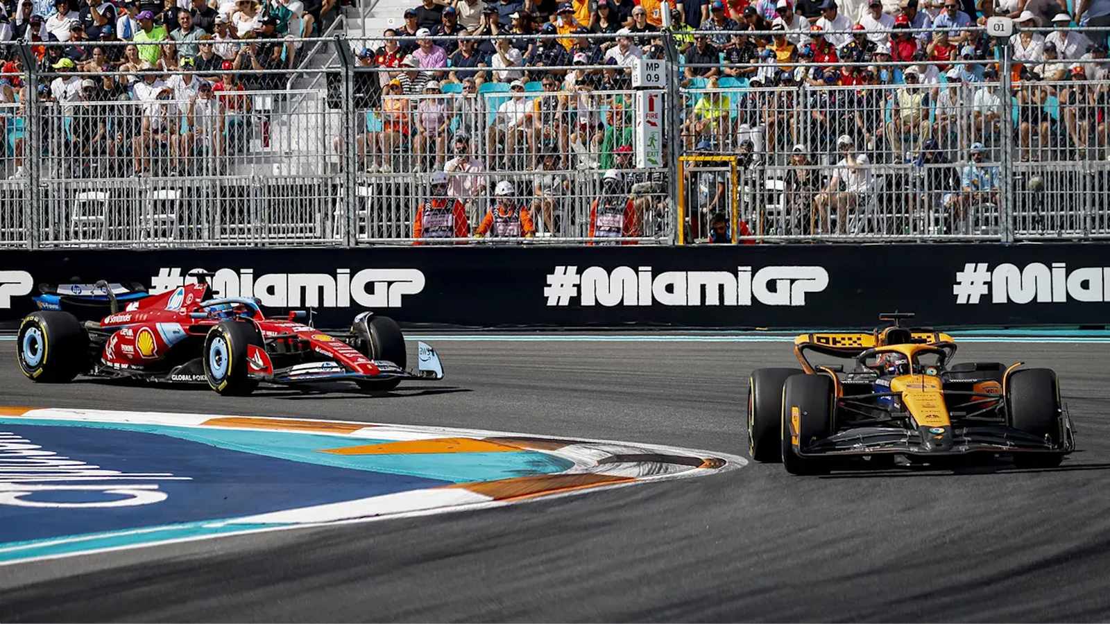 A red Ferrari and orange McLaren Formula 1 car racing on track