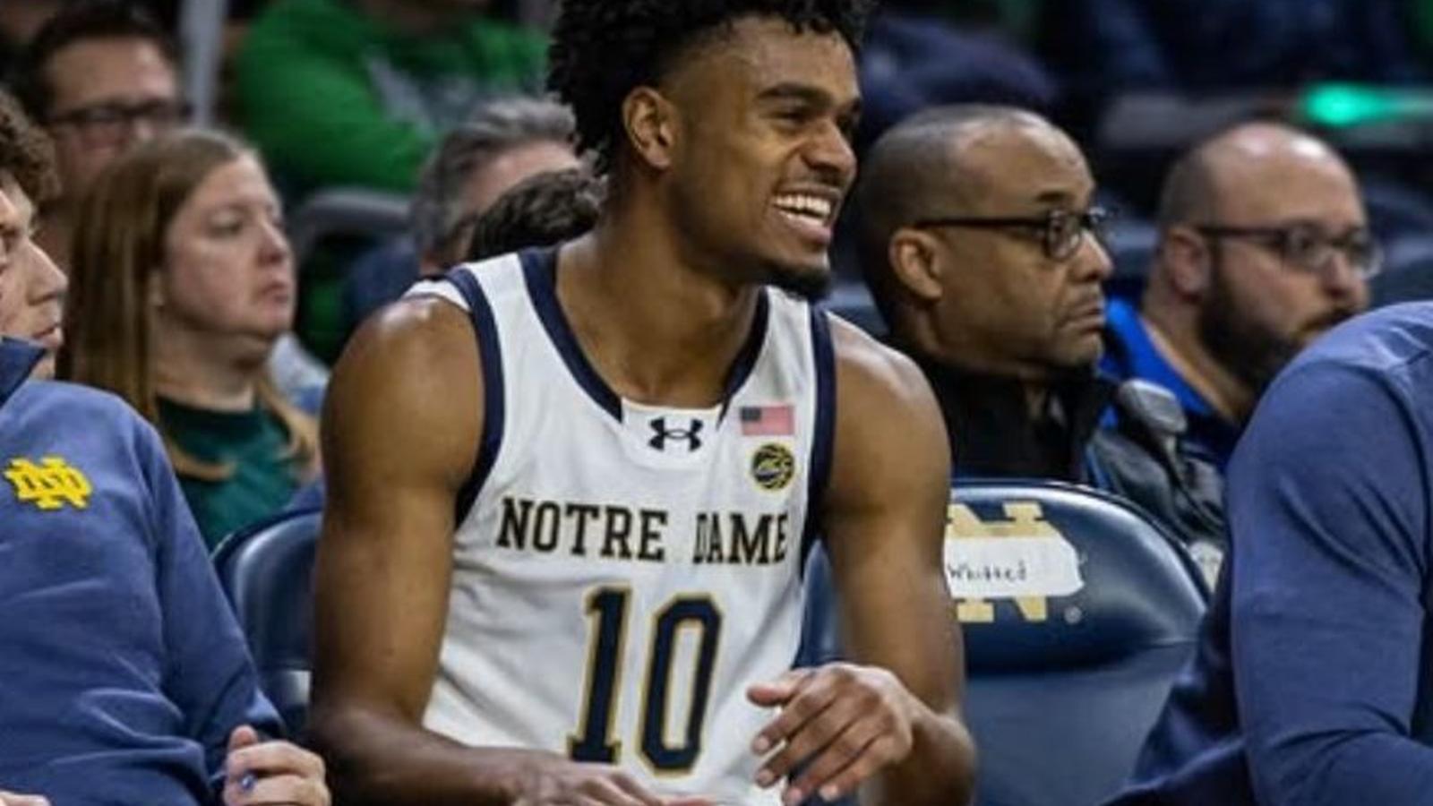 Jalen Haralson wearing a Notre Dame basketball jersey sitting on the bench