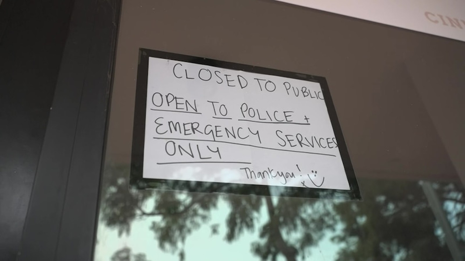 A handwritten sign on a glass door stating closed to public open to police