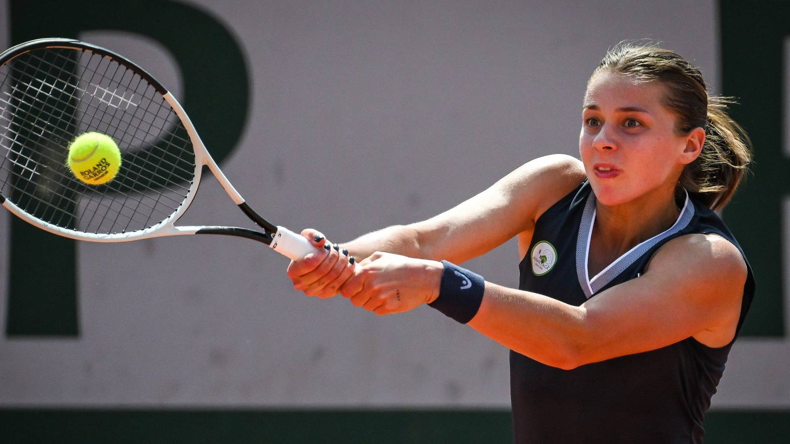Maja Chwalińska hitting a backhand shot during a tennis match at Roland Garros
