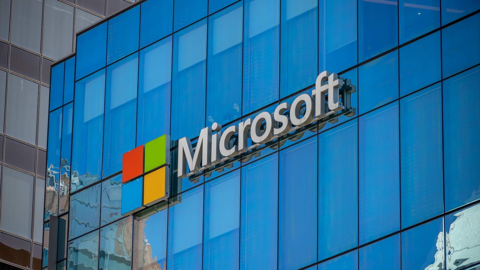 The Microsoft logo mounted on the glass facade of a modern corporate building