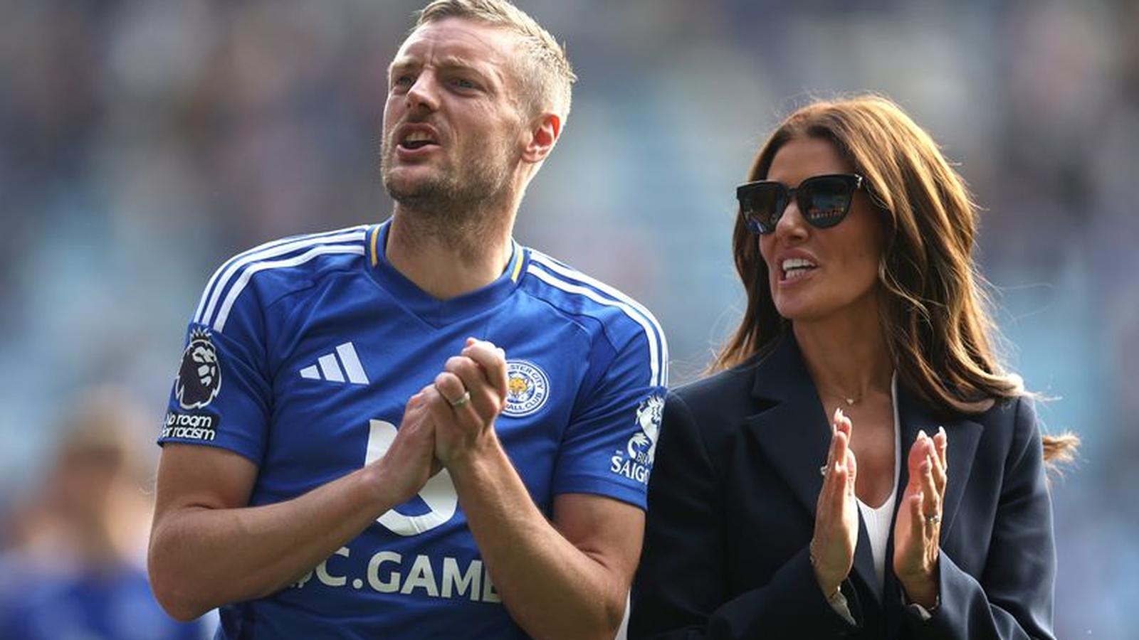 Rebekah Vardy wearing sunglasses standing next to her husband Jamie Vardy at stadium