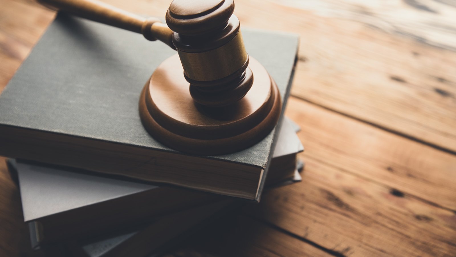A wooden gavel resting on top of a thick book.