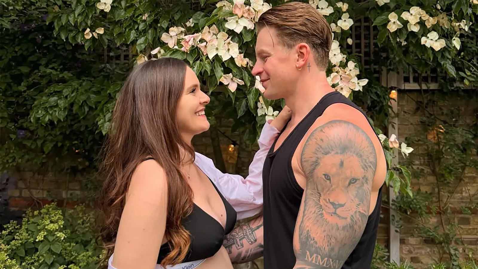 Holly Ramsay and Adam Peaty standing together outdoors, Holly showing her baby bump