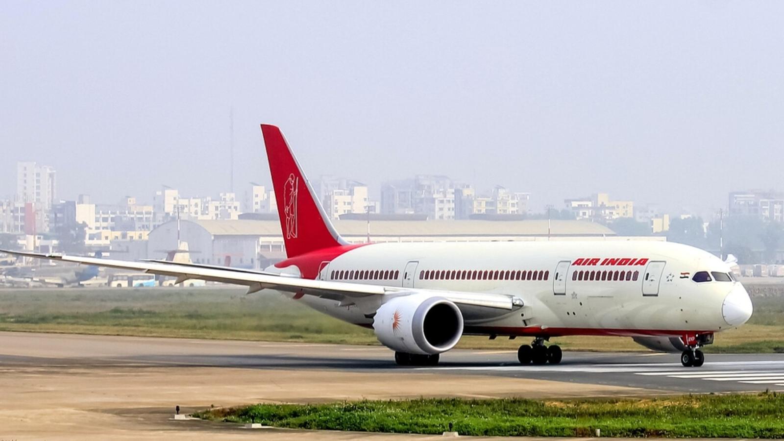 An Air India passenger jet taxiing on the airport runway during the day